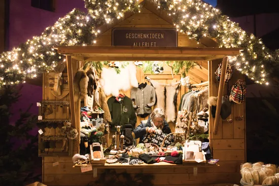 Christmas market stall with handmade winter clothes, gifts and warm lighting